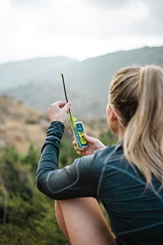 Hiker using a handheld radio in the mountains